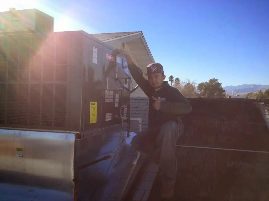 HVAC technician performing Boiler Repair on a rooftop unit in Redland